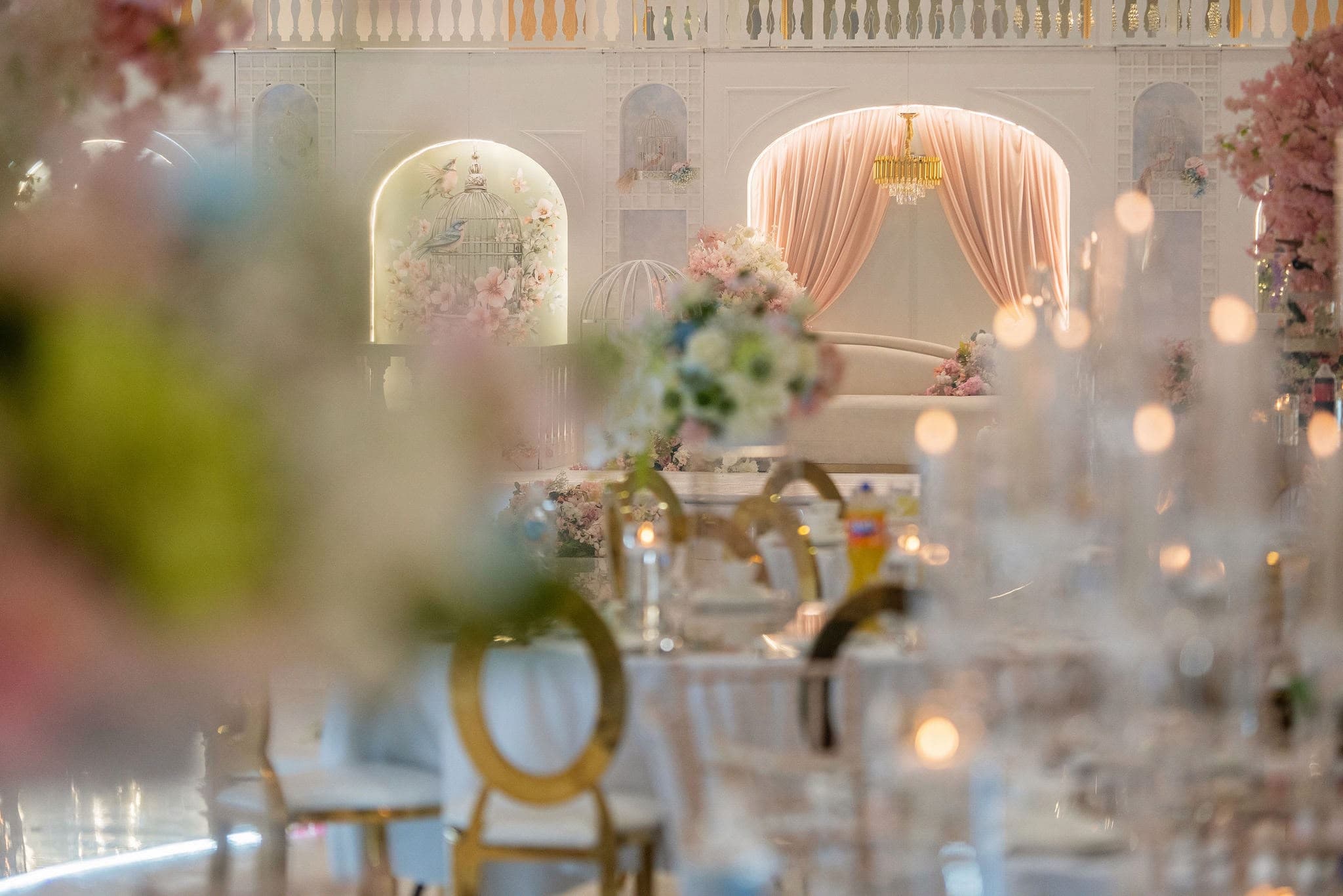 A soft-focus view across white and blush floral arrangements