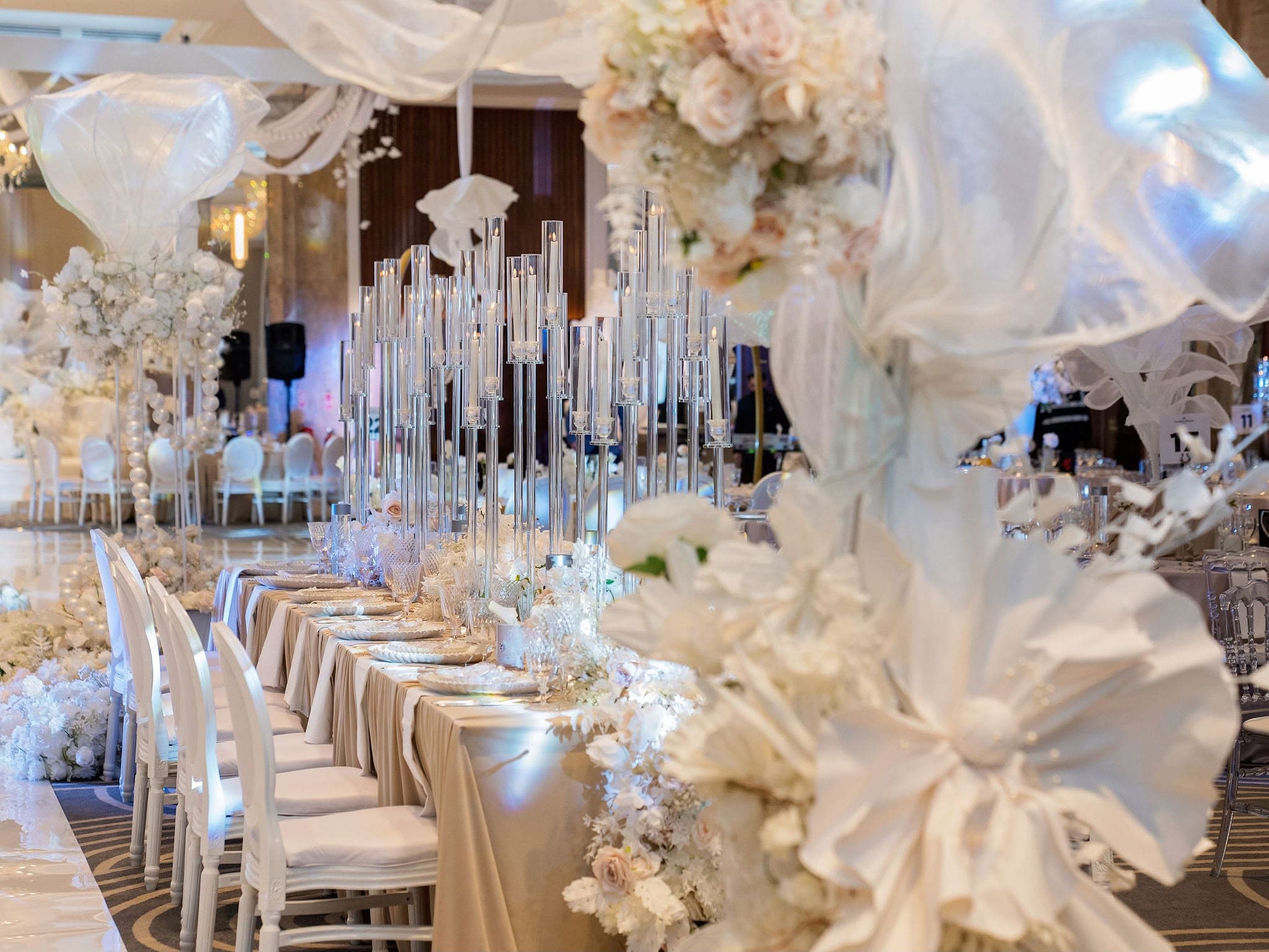 Oversized white floral decorations above blue and gold reception tables