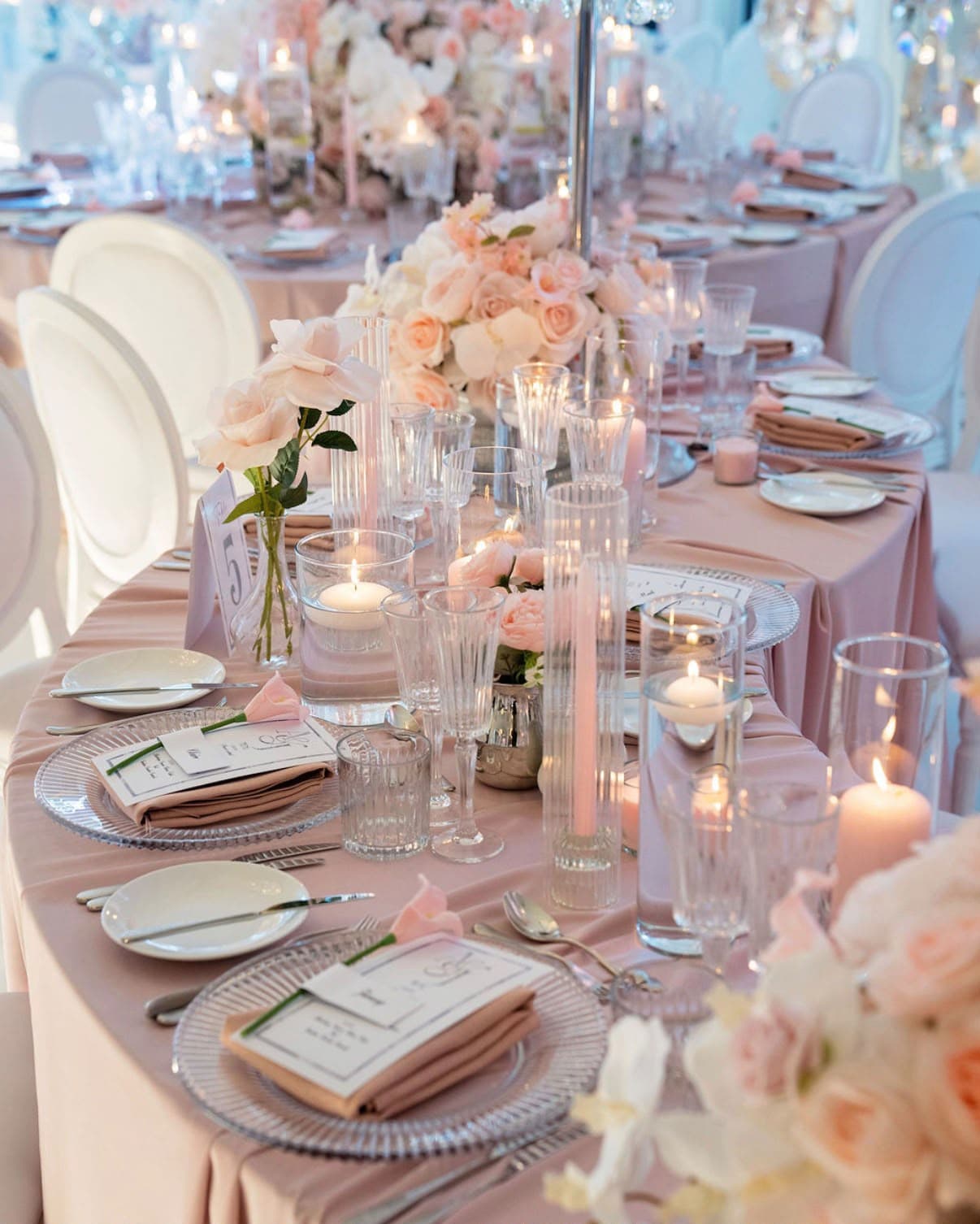 Pink place settings beneath peach and blush flowers